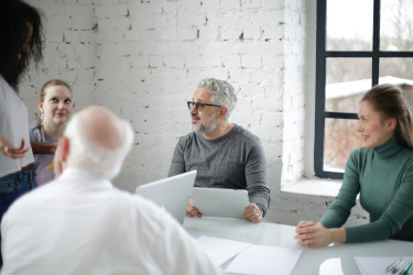 Five people having a discussion in a meeting room